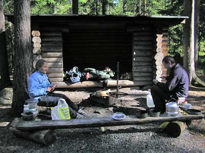 Retkeläisiä ruokaa valmistamassa laavulla.