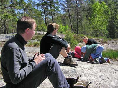 Lepääviä retkeläisiä ja leikkiviä lapsia